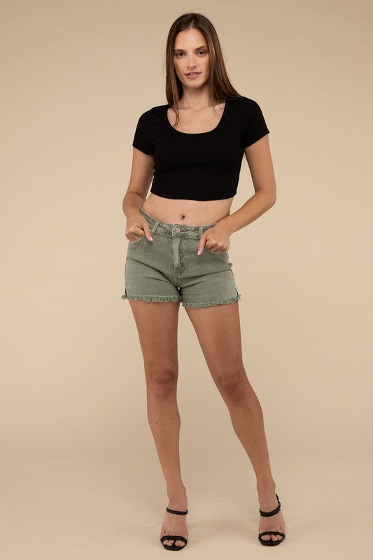 A person wearing green Acid Washed Frayed Cutoff Hem Shorts, holding the hem. Only the torso and thighs are visible.