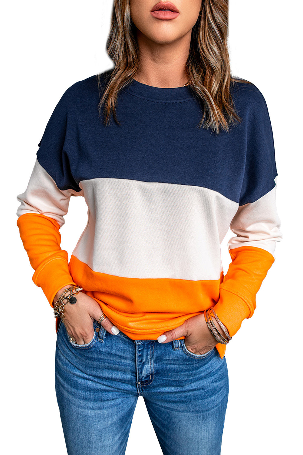 Person with wavy, shoulder-length hair wearing a Colorblock Orange Contrast Stitching Sweatshirt with Slits, paired with blue skinny fit jeans, standing with back to the camera against a gray textured wall.