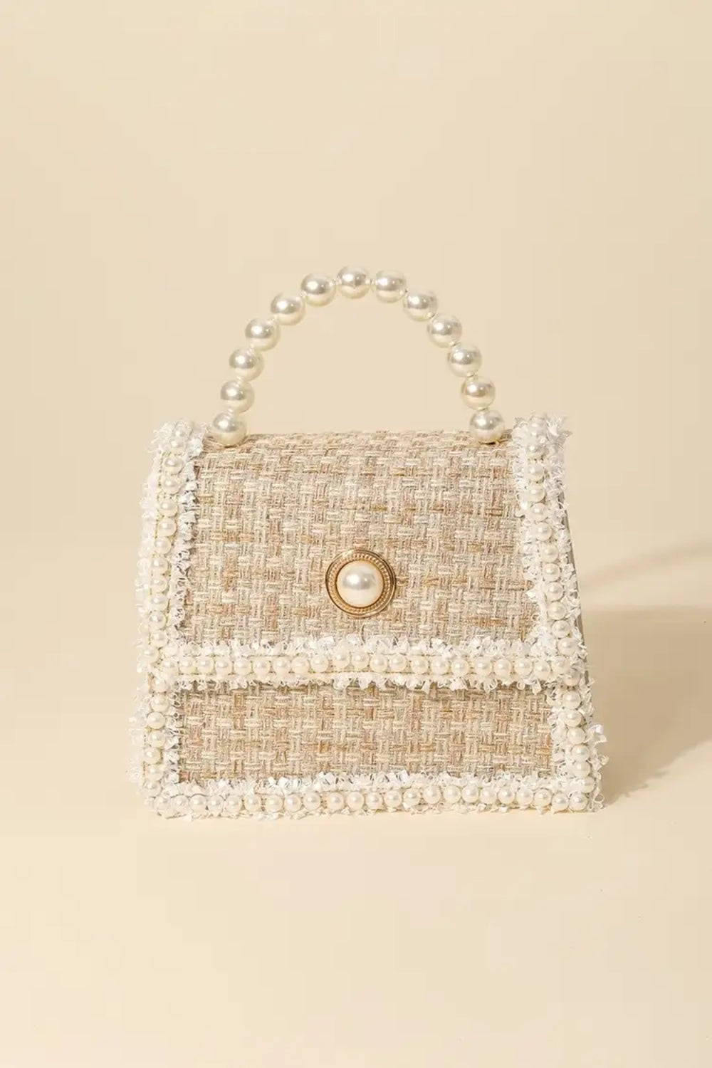 The Fame Pearly Trim Woven Handbag is a compact, rectangular accessory that blends exquisite woven craftsmanship with an elegant design. Its pearl handle and trim accentuate the textured fabric, and a pearl button closure provides the perfect finishing detail.