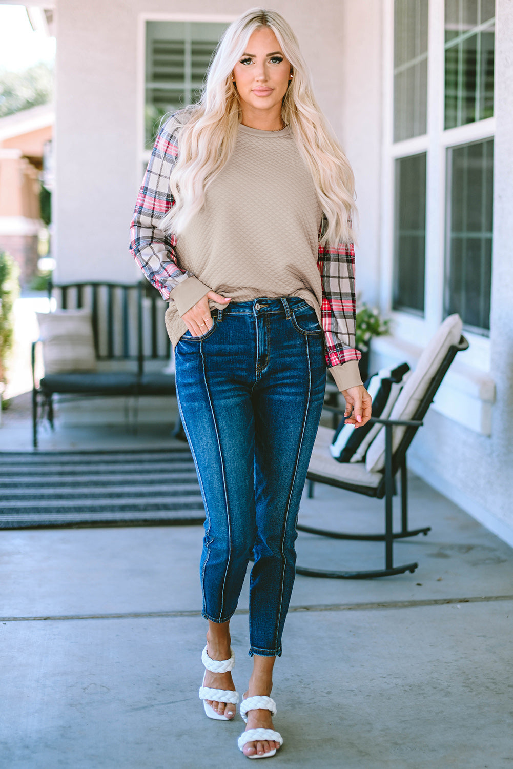 A person with long blonde hair stands with their back to the camera, wearing an Apricot Plaid Raglan Sleeve Sweatshirt and blue jeans.