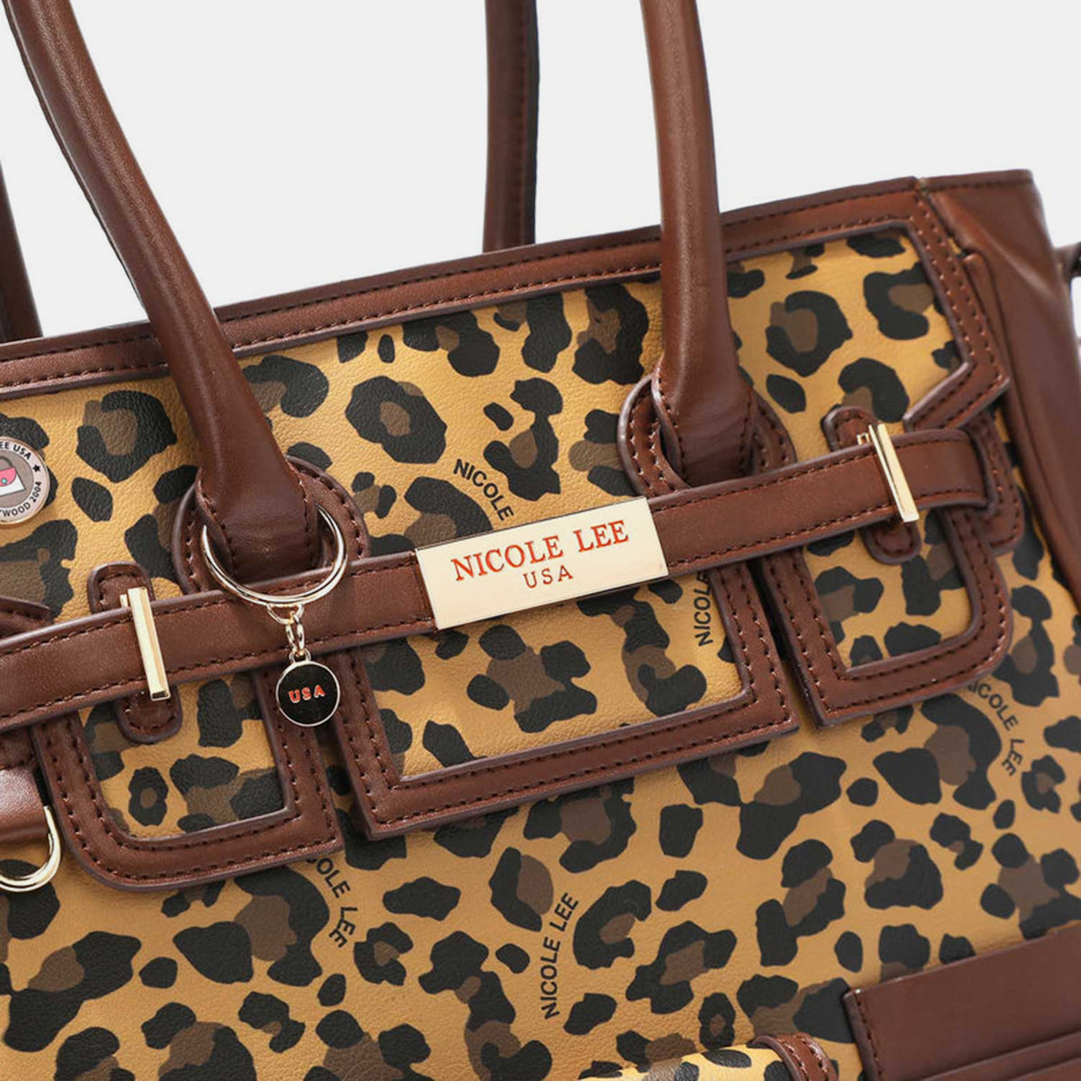 The Nicole Lee USA Leopard Large Tote Bag is a chic leopard print handbag made from vegan leather, featuring two handles, multiple pockets, a buckle, and zipper details.