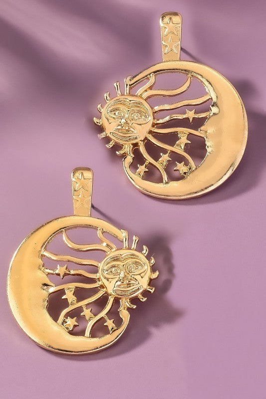 A close-up shows a person wearing the Sun Inside a Crescent Hoop Drop Earrings in large, gold-toned style, highlighting the intricate design with their hand.