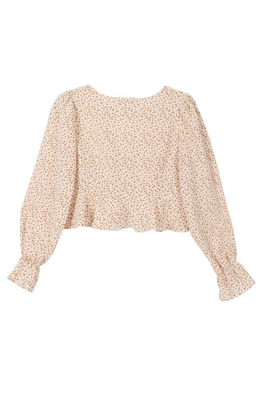 A person wearing an LS floral frill blouse with puff sleeves and beige shorts poses against a neutral background.