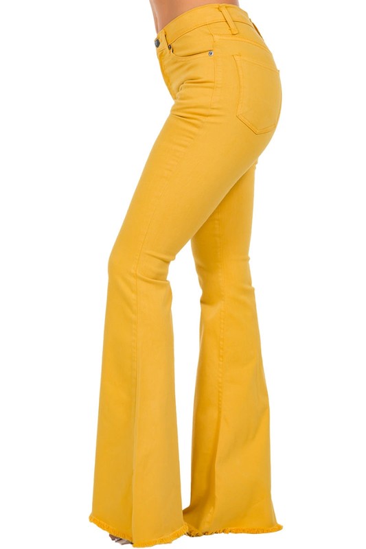 Person wearing the Bell Bottom Jean in Mustard with a 30-inch inseam, featuring a high-waisted fit and frayed hem.