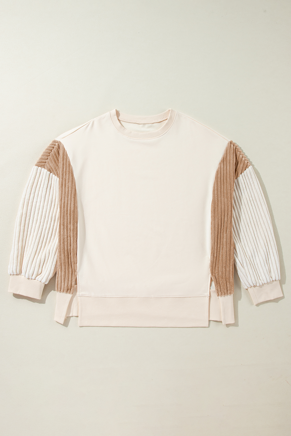 A person with long hair is wearing an Apricot Corduroy Patchwork Drop Shoulder Long Sleeve Sweatshirt, standing with their back to the camera against a light blue corrugated metal wall.