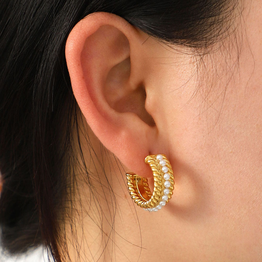 Close-up of a person's ear wearing Stainless Steel Pearl C-Hoop Earrings featuring a row of small synthetic pearls.