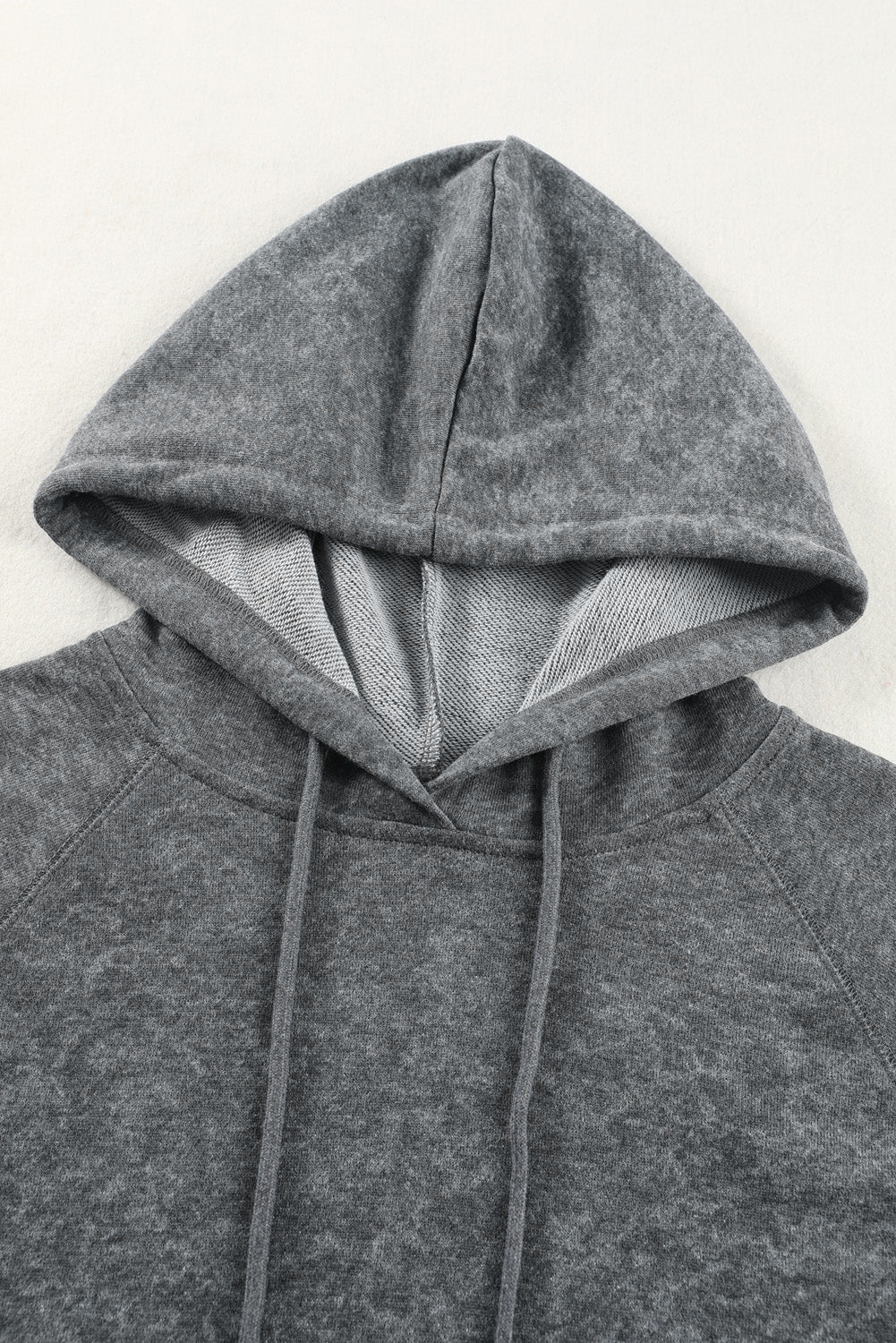 A person with blonde hair is standing with their back to the camera, wearing a Gray Mineral Wash Kangaroo Pocket Drawstring Pullover Hoodie.