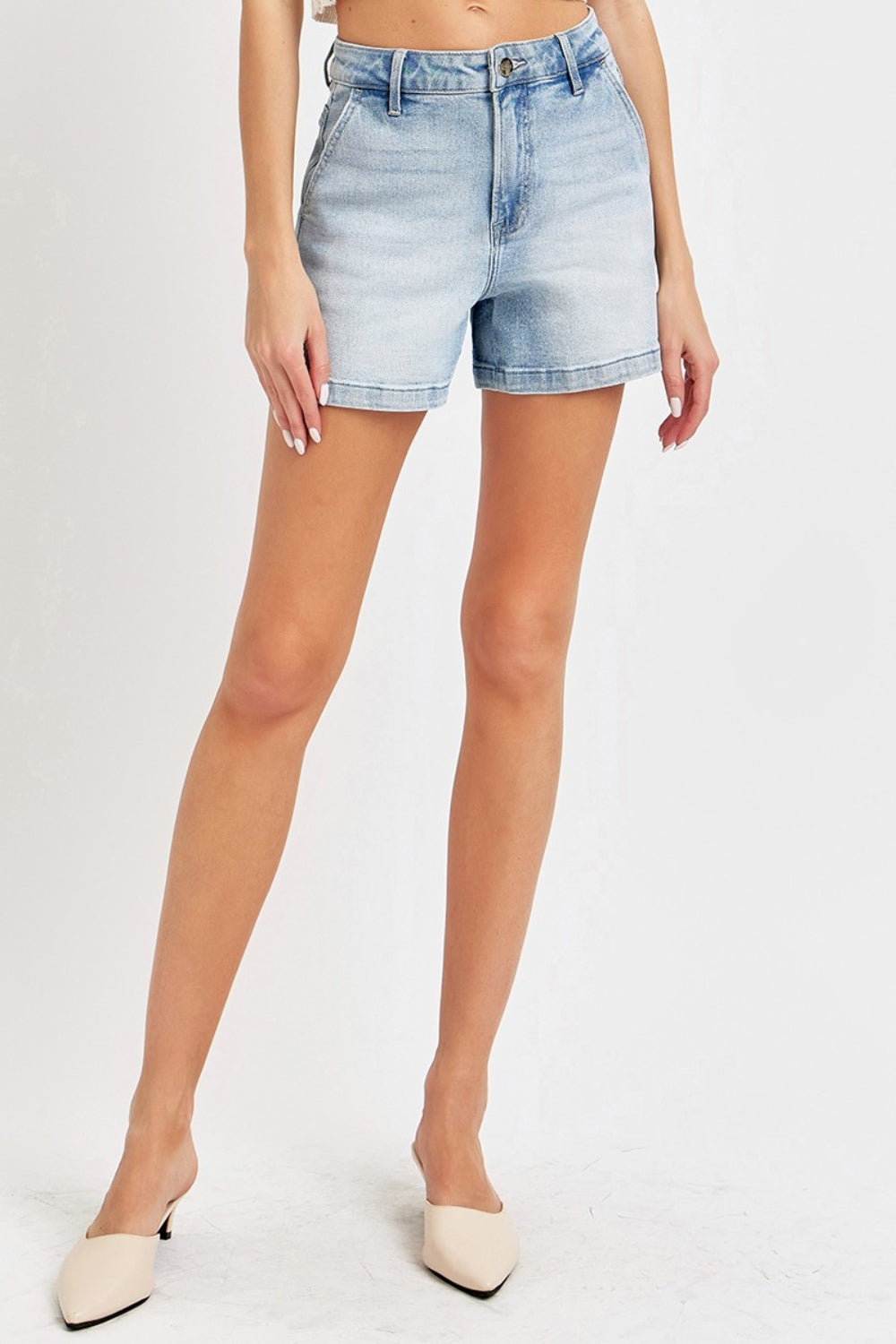 Someone wearing the Risen Full Size High Rise Denim Shorts in a light blue wash, featuring a button and zipper front, appreciates their flattering silhouette, making them a versatile wardrobe staple.