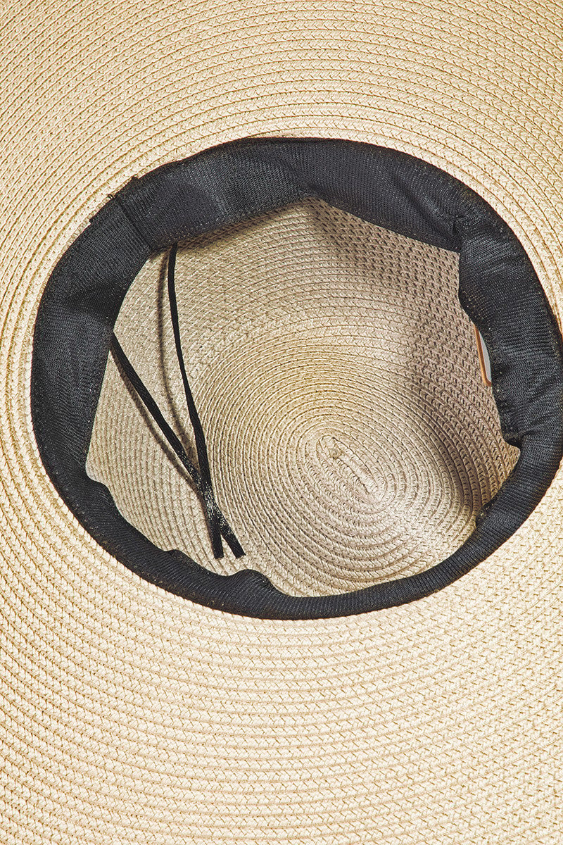 The Fame Rope Strap Wide Brim Weave Hat features a wide-brimmed straw design with a brown leather band and decorative silver accents, perfect for sun protection at the beach.