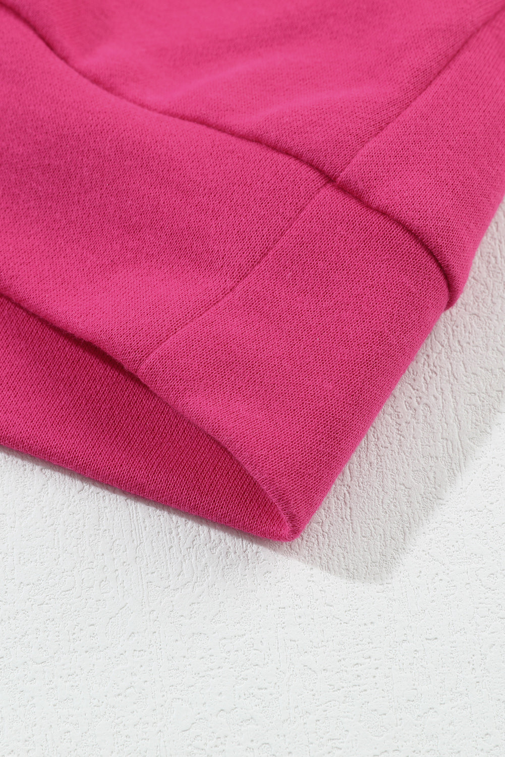 A person with wavy hair is standing with one hand on their hip, wearing a Strawberry Pink MERRY Christmas Tree Sequin Patchwork Sweatshirt and blue jeans. The person is facing away from the camera.