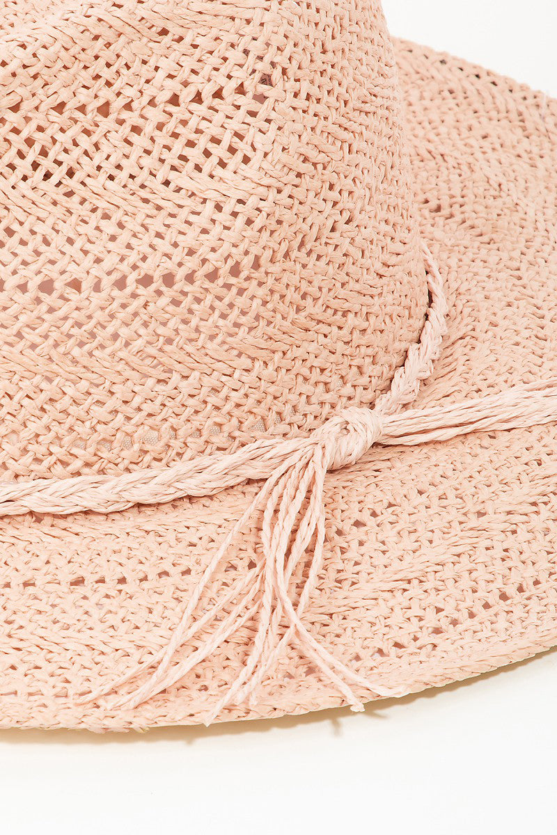 The Fame Braided Rope Straw Hat, in a charming pink color, is a perfect addition to your summer wardrobe. It features a wide brim and fringe detail around the crown, offering stylish sun protection against a light background.