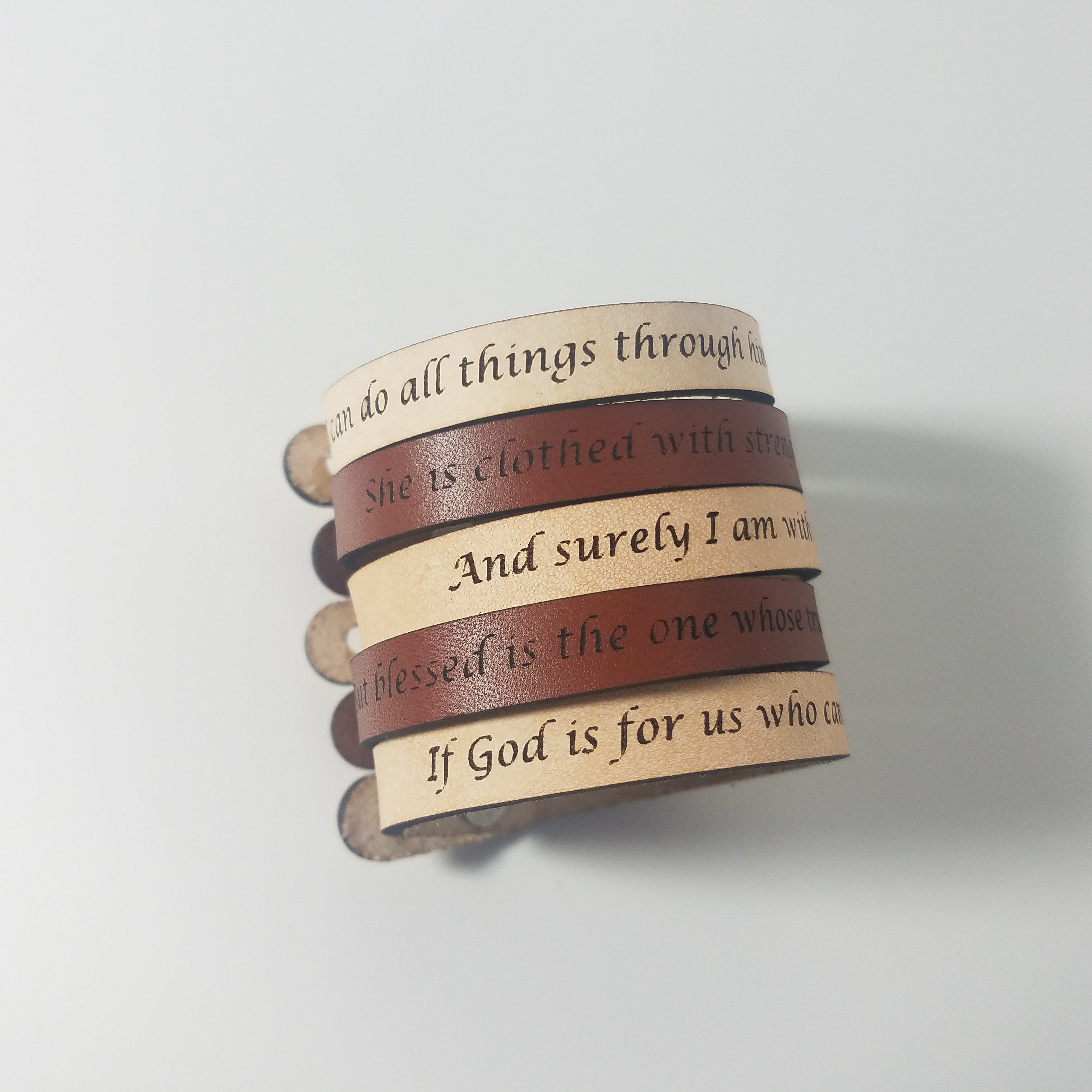 The Spiritual Quote Bracelet made of genuine leather features an adjustable button closure and is inscribed with the message: "If God is for us, who can be against us.