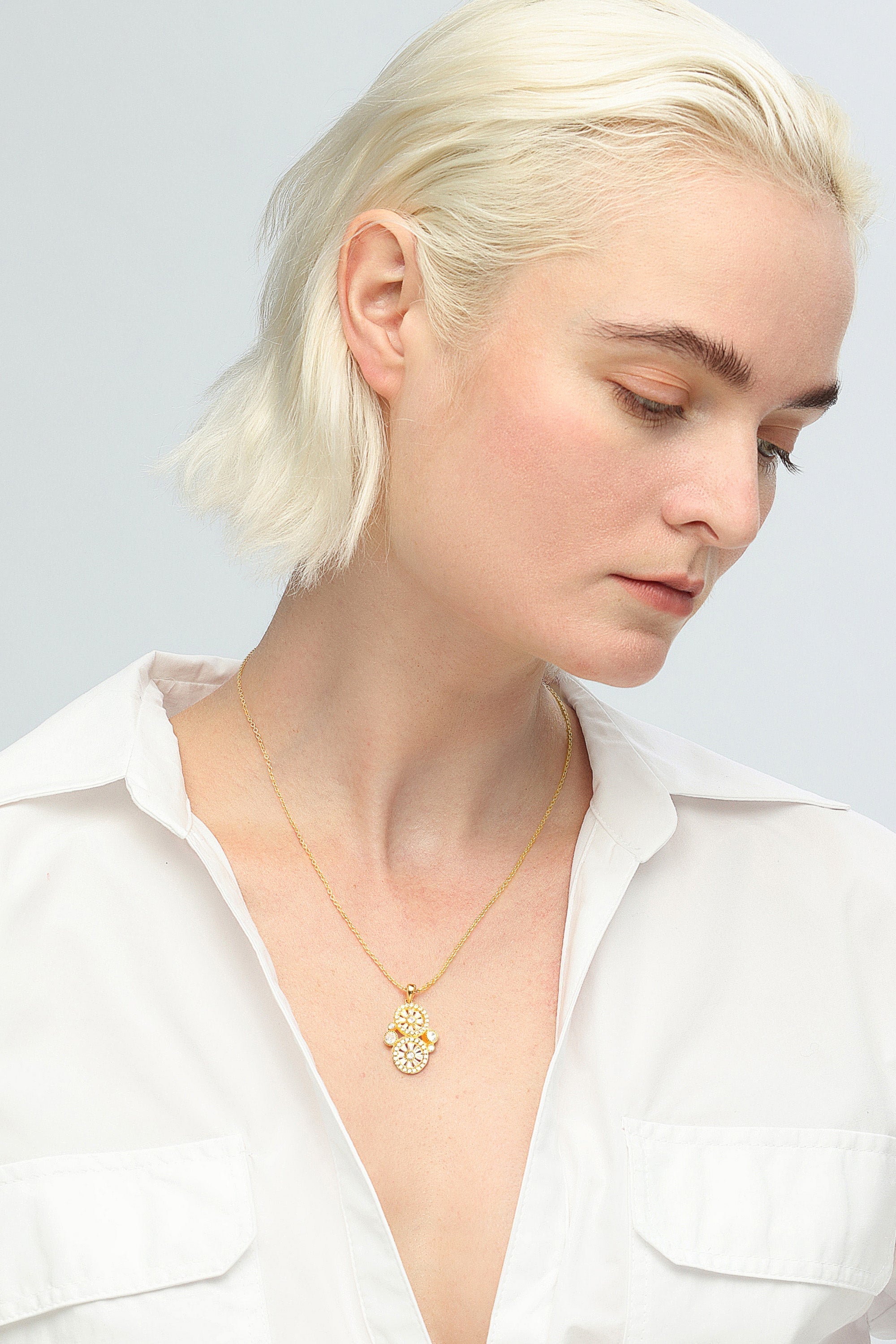 Gold plated brass Gold Wheel of Fortune Necklace with a pendant featuring three circular designs, each embellished with multiple diamonds and connected vertically.