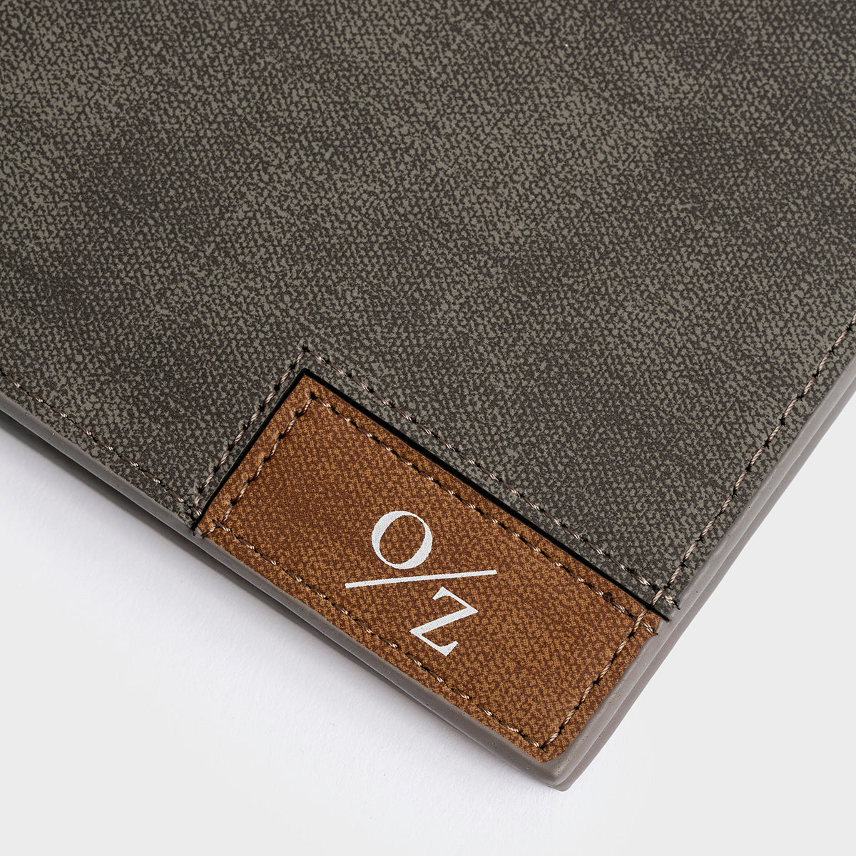 A Clifton - Casual Wallet in blue, featuring a brown patch with the "O/Z" logo on the front, along with convenient inner pockets, presented against a plain white background.