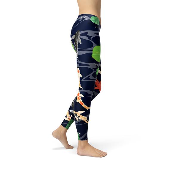 A person is modeling the Womens Koi Fish in Pond Leggings, which feature a koi fish and lily pad pattern on a dark background, crafted from smooth microfiber yarn with four-way stretch for ultimate comfort and flexibility.