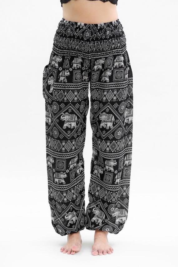 Person wearing Black ELEPHANT Pants Women Boho Pants Hippie Pants Yoga, featuring an elastic waist and black and white elephant pattern, shown in two poses.