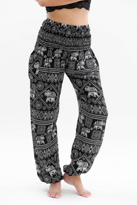 Person wearing Black ELEPHANT Pants Women Boho Pants Hippie Pants Yoga, featuring an elastic waist and black and white elephant pattern, shown in two poses.