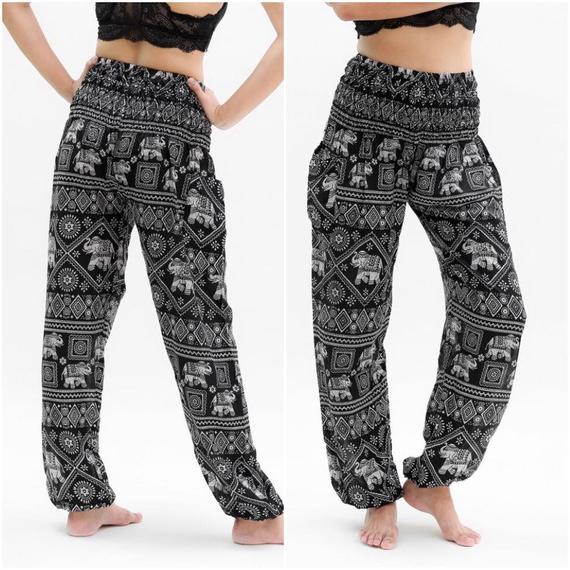 Person wearing Black ELEPHANT Pants Women Boho Pants Hippie Pants Yoga, featuring an elastic waist and black and white elephant pattern, shown in two poses.