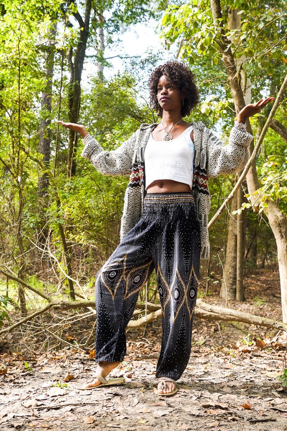 Person wearing a sleeveless black top and Black PEACOCK Women Boho Pants Hippie Pants Yoga Pants with an elastic waist, standing barefoot against a white background. The harem pants are made from 100% Rayon, ensuring both comfort and style.