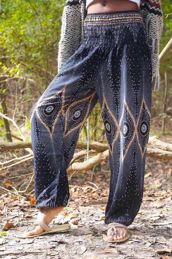 Person wearing a sleeveless black top and Black PEACOCK Women Boho Pants Hippie Pants Yoga Pants with an elastic waist, standing barefoot against a white background. The harem pants are made from 100% Rayon, ensuring both comfort and style.