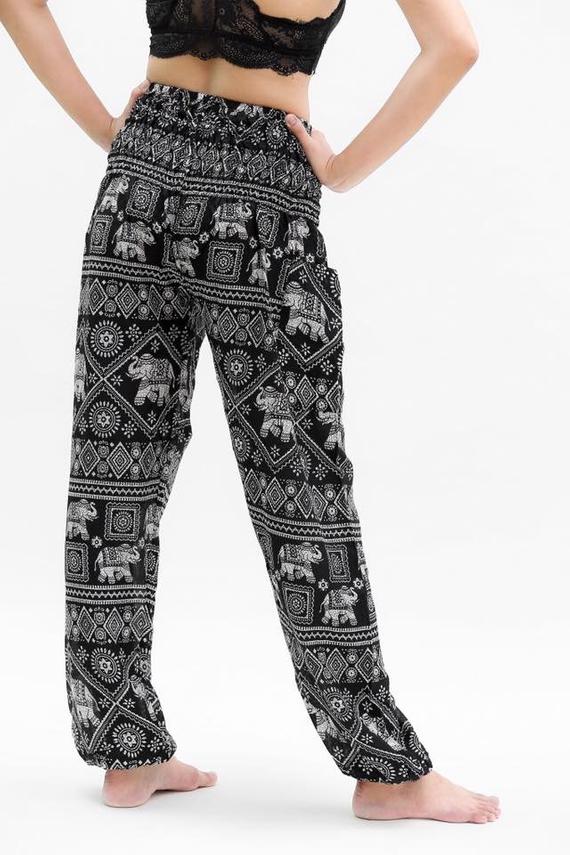 Person wearing Black ELEPHANT Pants Women Boho Pants Hippie Pants Yoga, featuring an elastic waist and black and white elephant pattern, shown in two poses.