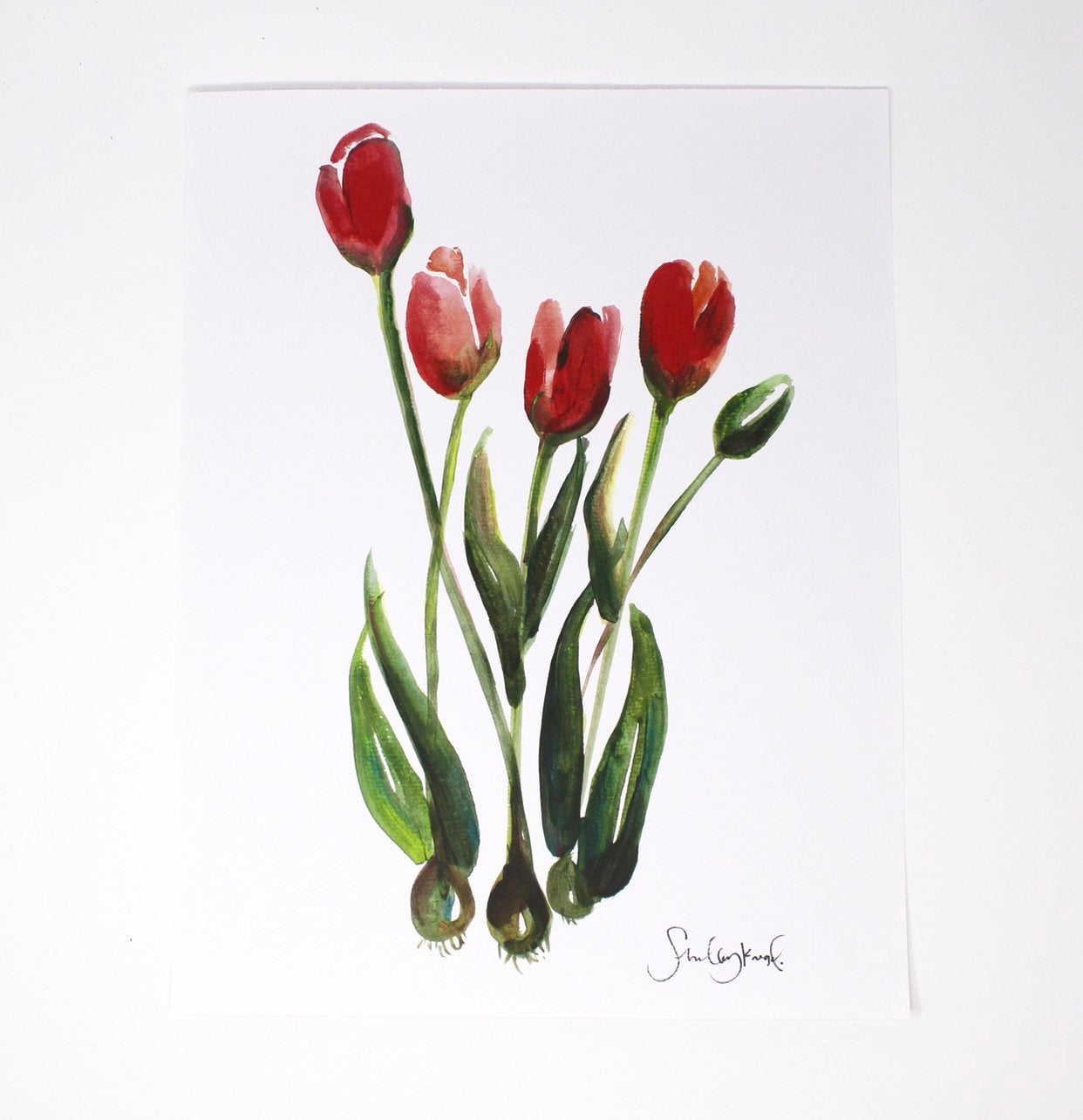 A wall art piece titled "Tulips Art Print," measuring 11x14, features a tulip painting with vibrant red tulips and lush green stems and leaves on a crisp white background, perfect for home decor.