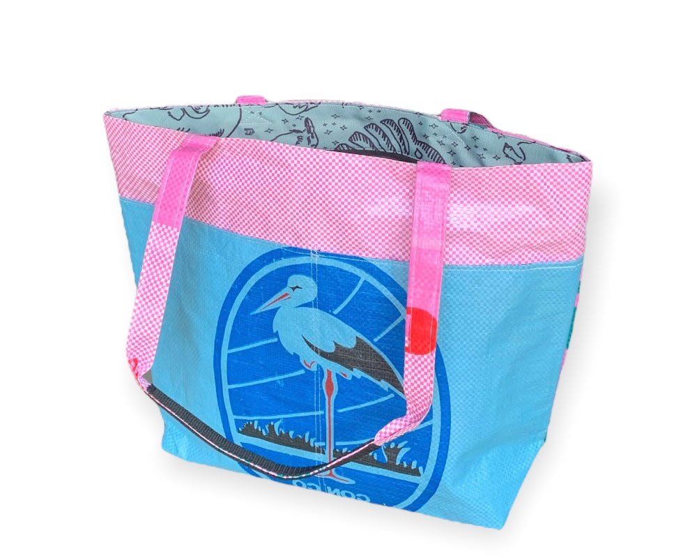 This lively Barrel Tote, made from recycled rice sacks, features whimsical frog graphics and genuine Vietnamese text, embodying a Portland-inspired design.