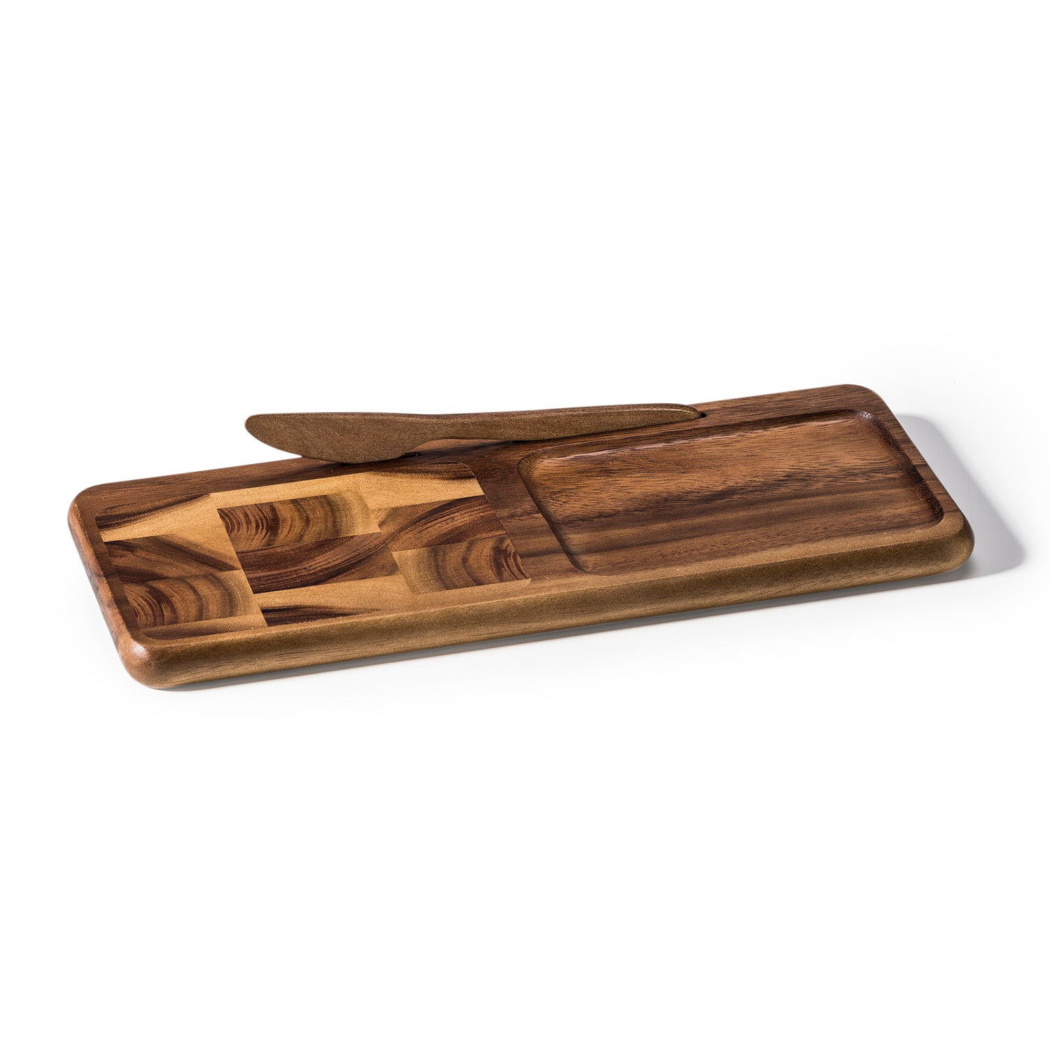 The Bornholm Cheeseboard with Knife, made from acacia wood, showcases a geometric pattern on the left and a recessed area on the right, making it an elegant choice for serving cheese.