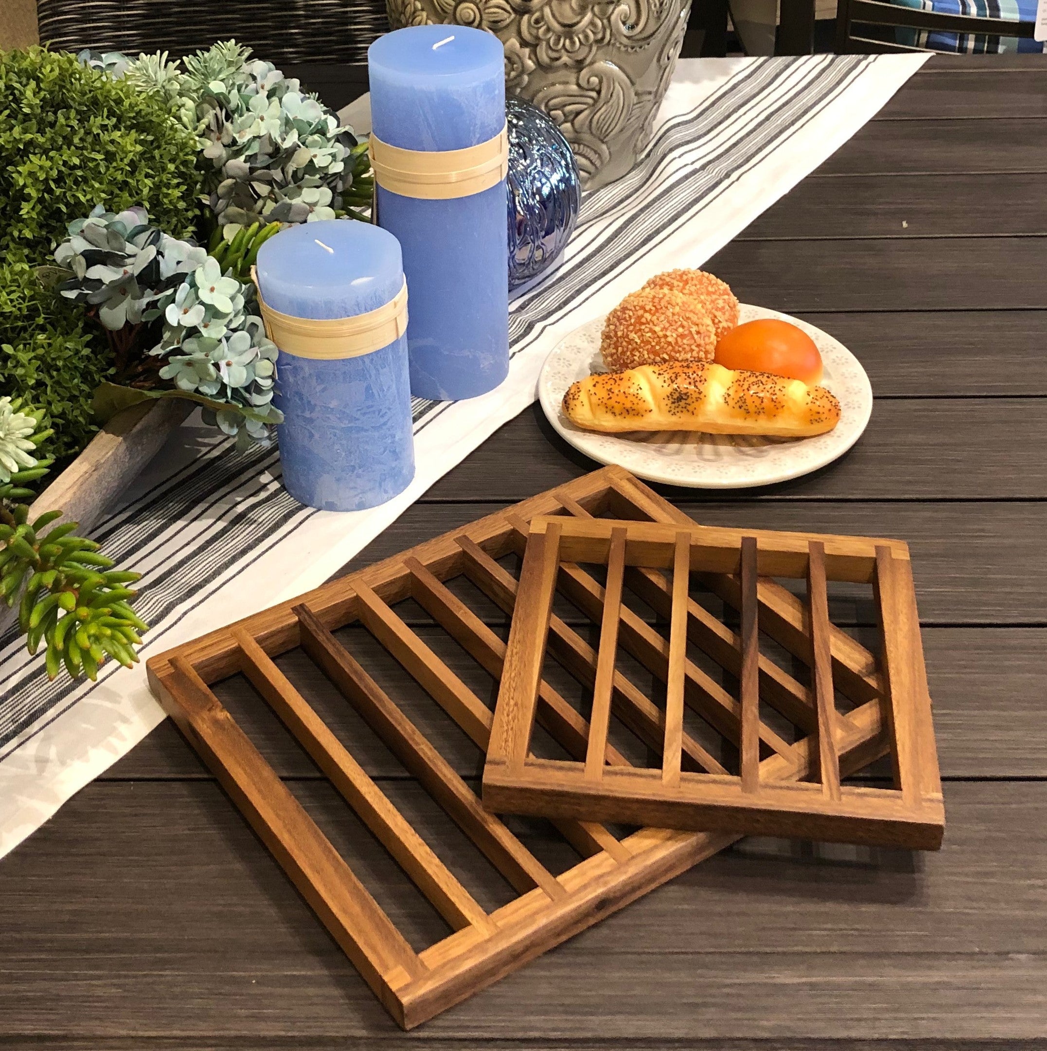 The Trivets set of 2, featuring a larger rectangular tray and a smaller square tray both crafted from acacia wood, are elegantly displayed side by side on a white background. These pieces not only enhance your decor but also offer excellent heat protection for table settings.