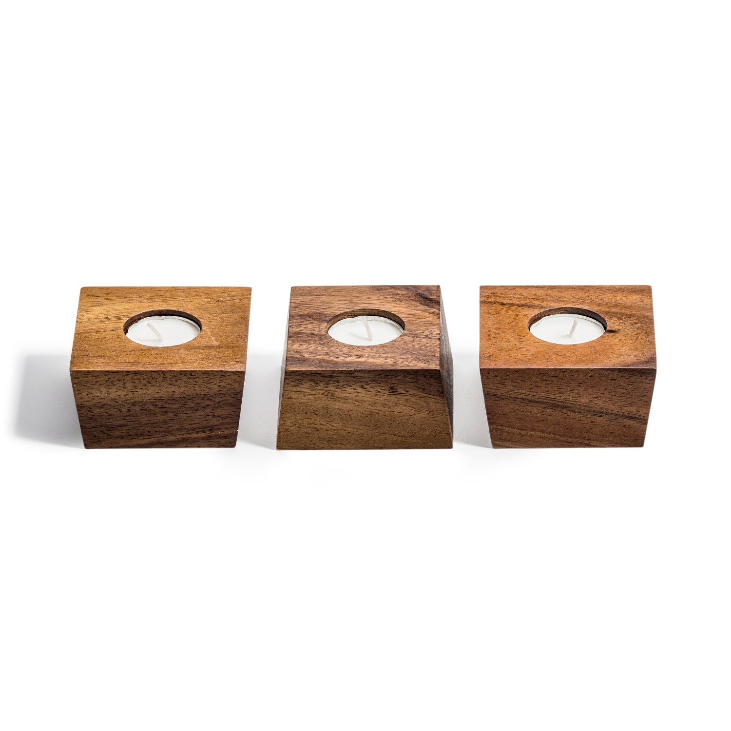 A set of three acacia wood Candle Holders with circular cutouts, each holding a white candle, beautifully arranged in a row. This organic design adds warmth and elegance to any setting.