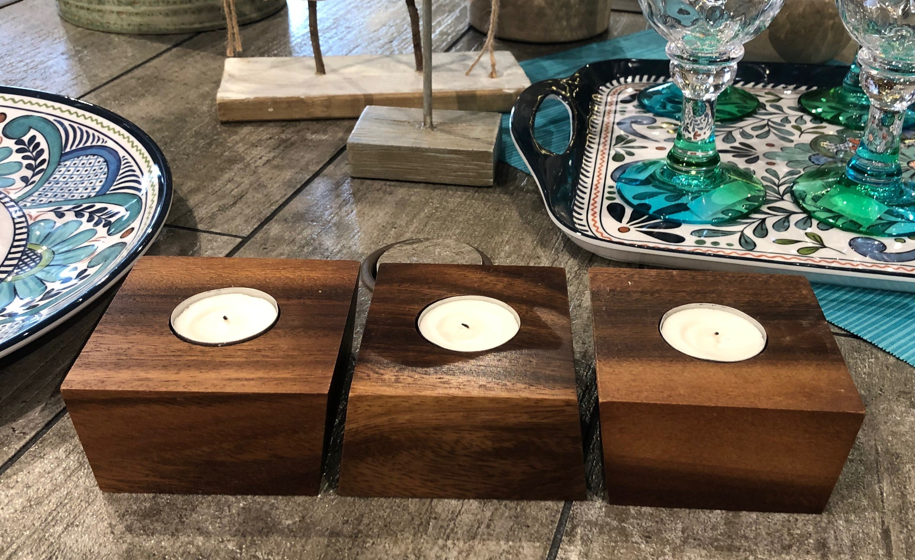 A set of three acacia wood Candle Holders with circular cutouts, each holding a white candle, beautifully arranged in a row. This organic design adds warmth and elegance to any setting.