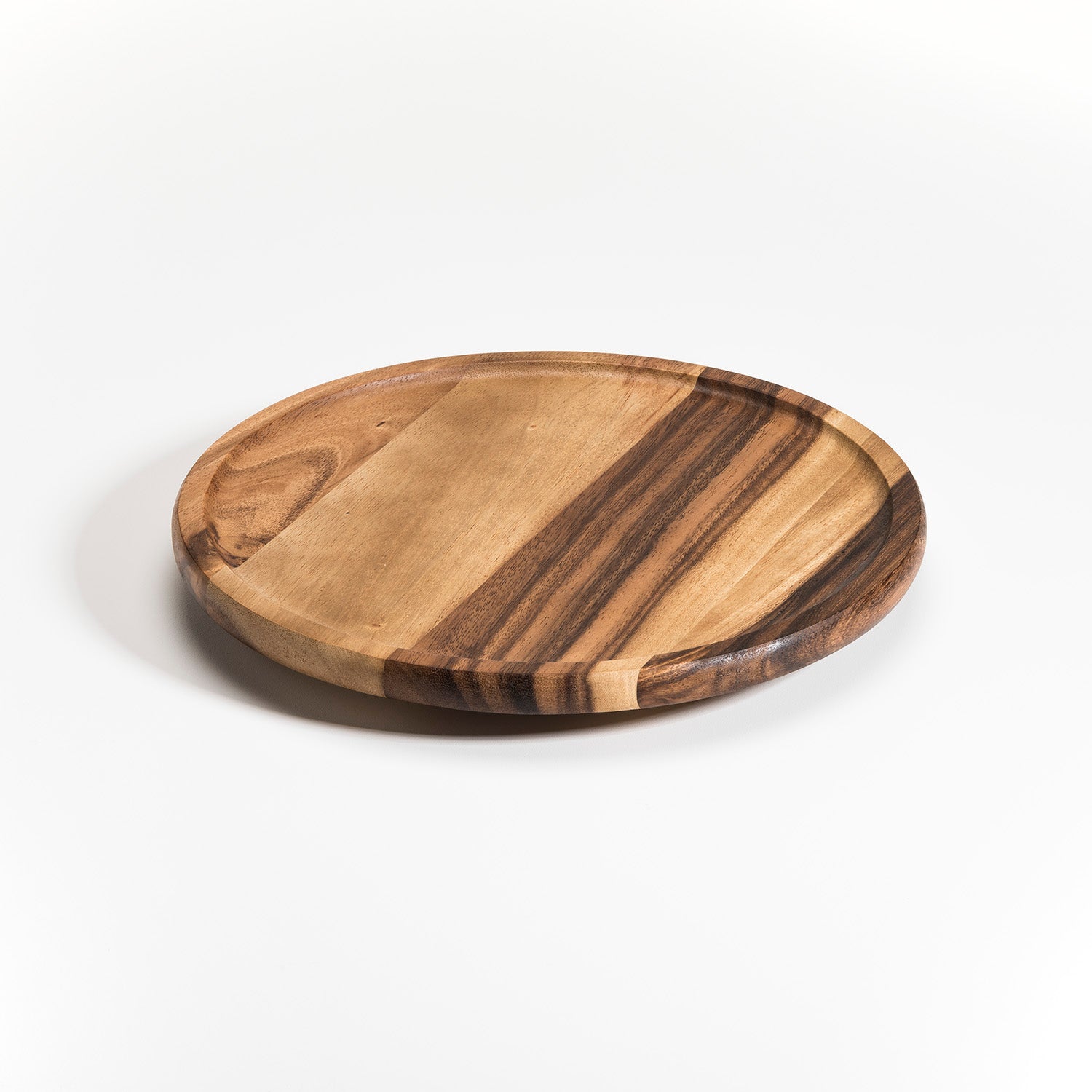 The Aarhus Lazy Susan is a round wooden serving board featuring a striped pattern with contrasting light and dark Acacia wood tones, set against a simple white background.