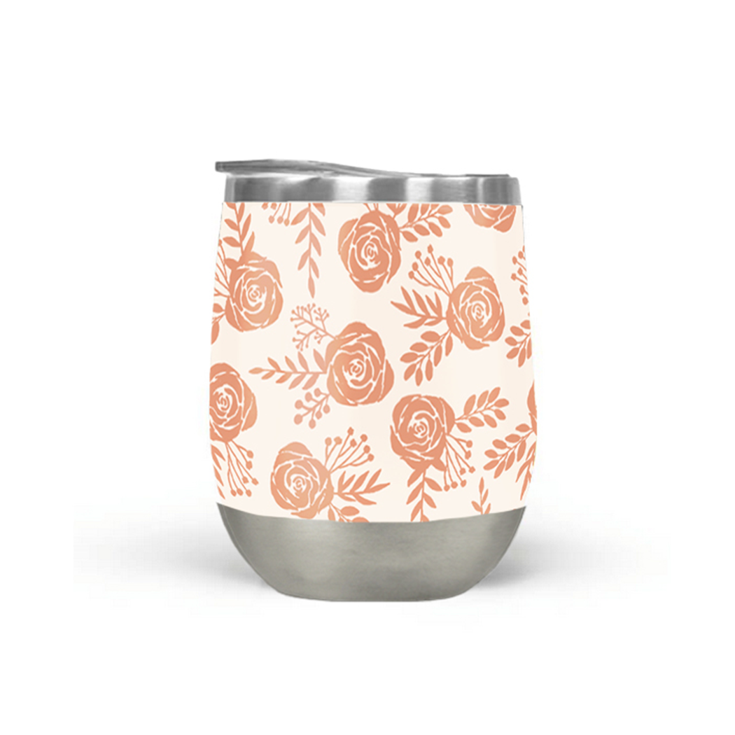 A Warm Orange Floral Wine Tumbler rests on a marble surface. Its double-wall insulation ensures your drink stays at the perfect temperature, with a blurred indoor setting in the background.