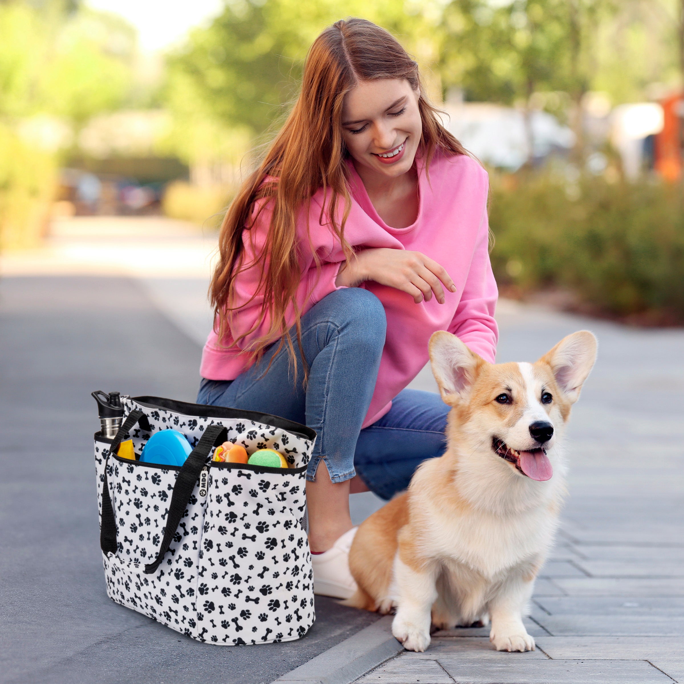 The Mobile Dog Gear Dogssentials Tote Bag features a paw print design, clear pouch, and small accessory bag. Speech bubbles display a dog declaring, "This is MY Bag!" alongside a person exclaiming, "And Mine!" Ideal for stylishly transporting all your dog's essentials.