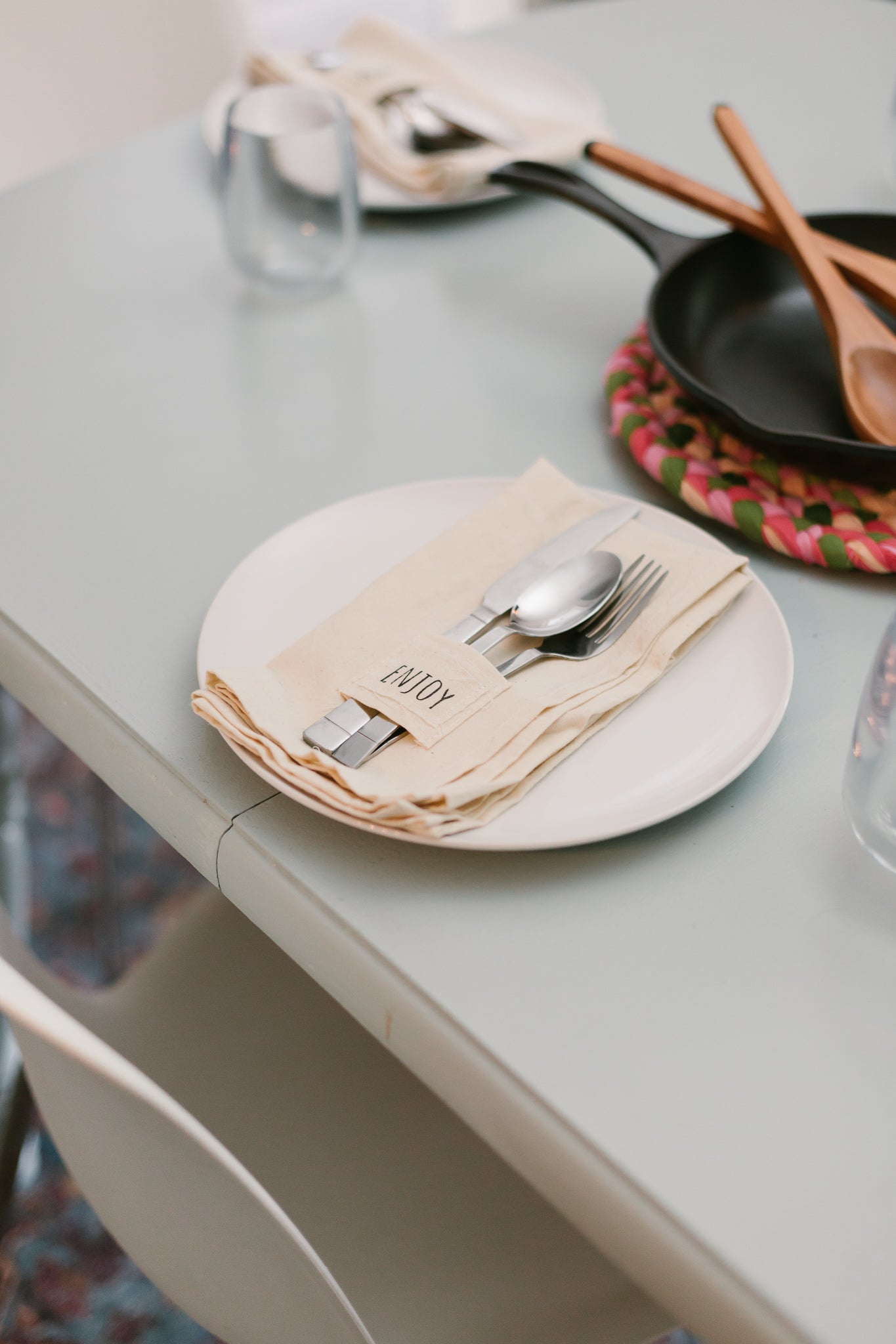 Pocket napkin set of four, skillfully crafted from up-cycled fabric, folded with a eucalyptus sprig and wooden ring, labeled "SAVOR.