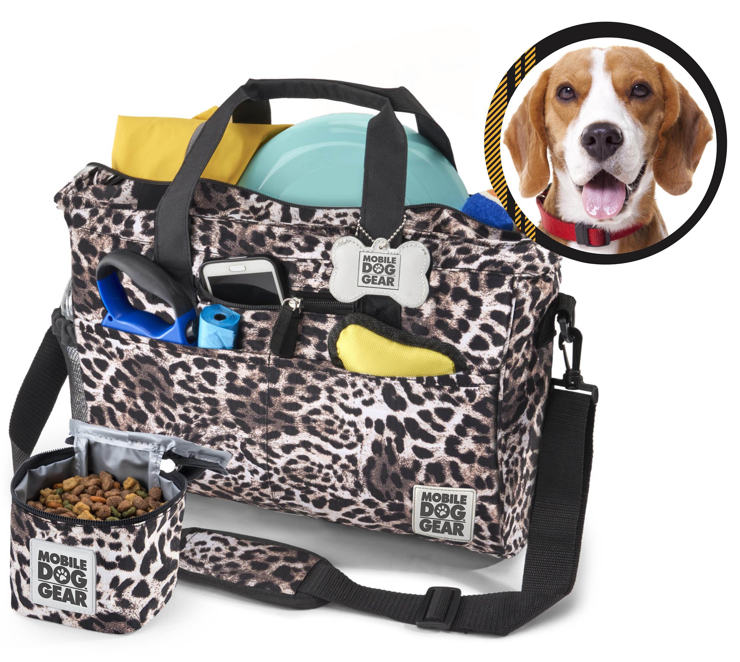 A black Day Away Tote Bag TM packed with various accessories like a phone, frisbee, and towel, accompanied by a small bag of dog food. A speech bubble from a dog image declares, "This is My Bag!" making it the perfect pet luggage for adventures.