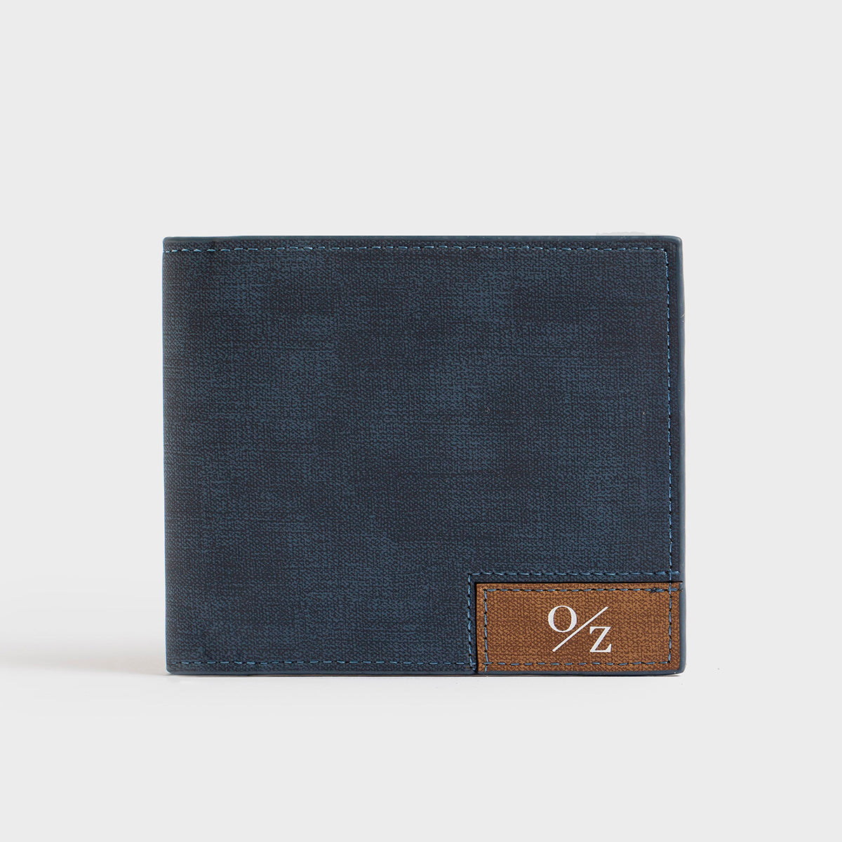 A Clifton - Casual Wallet in blue, featuring a brown patch with the "O/Z" logo on the front, along with convenient inner pockets, presented against a plain white background.