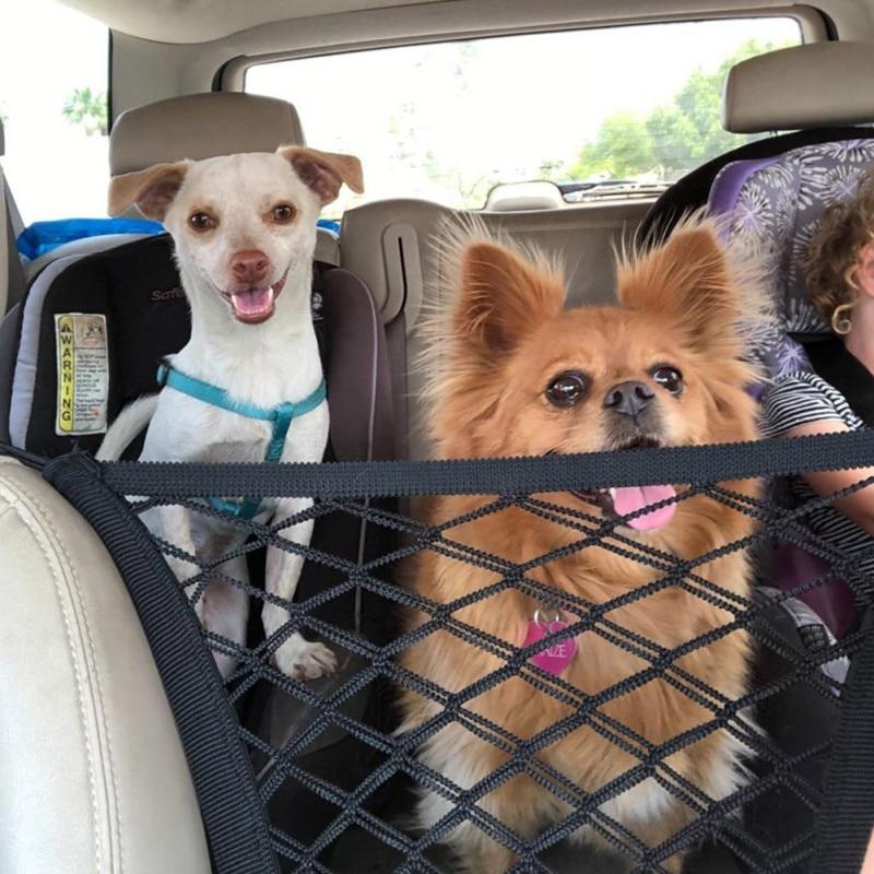 A shiba inu dog standing in a car, peeking through a black High Quality Premium Pet Car Net Petition barrier installed between two front seats.