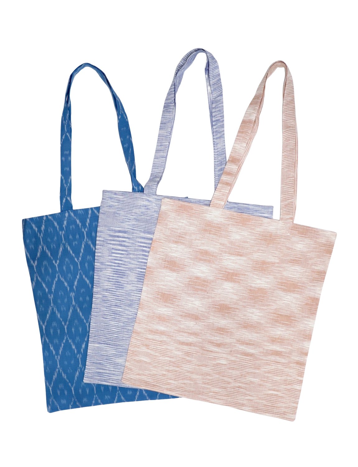 A trio of "Reusable Tote Bag: Multiple Prints Available" in ikat patterns featuring navy, red, and white are artfully displayed in a fan shape, embodying a dedication to zero waste living.