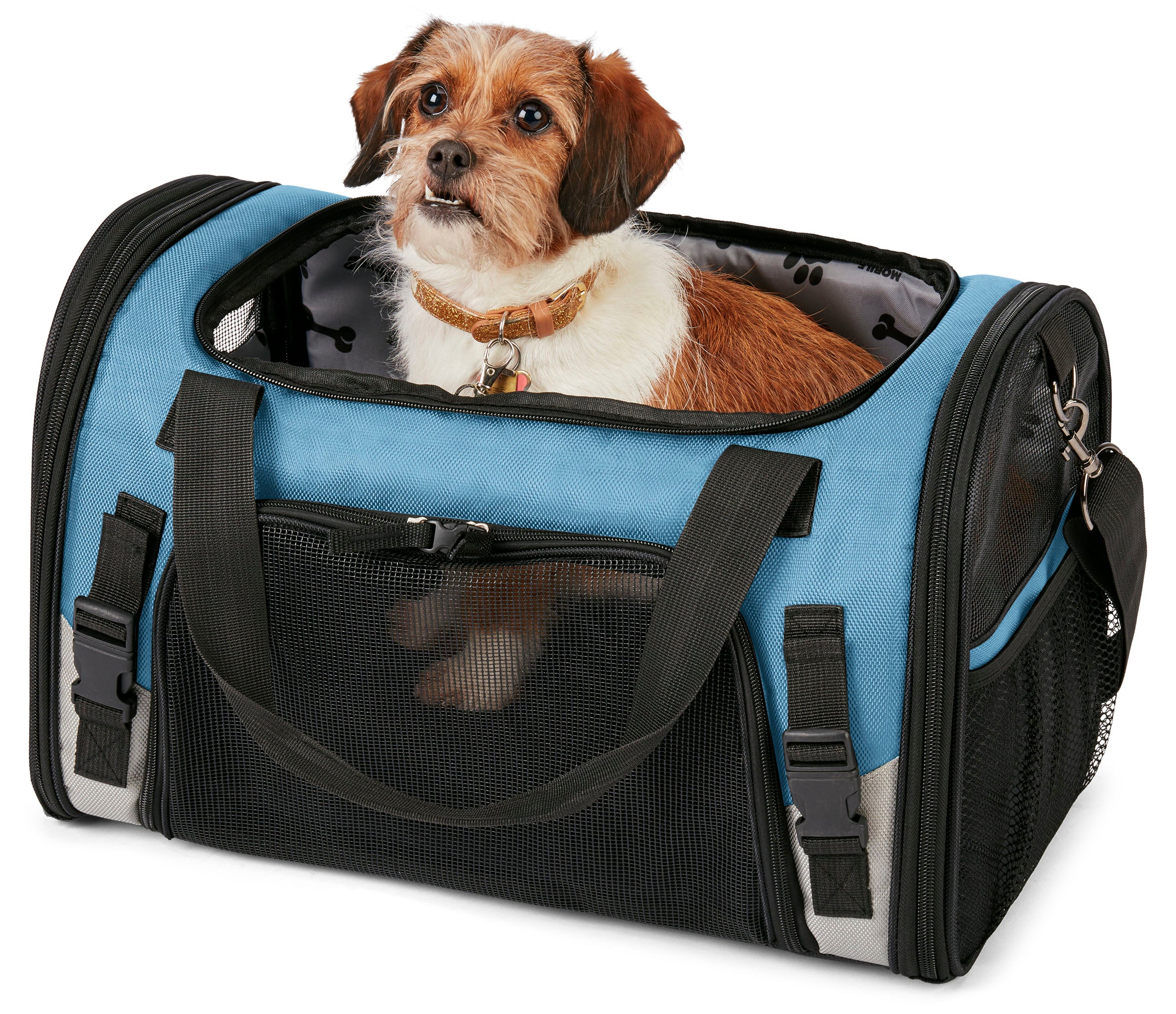 A small dog sits comfortably in a Mobile Dog Gear Pet Carrier Plus, complete with food and water bowls nearby. A speech bubble above says, "This is MY carrier!