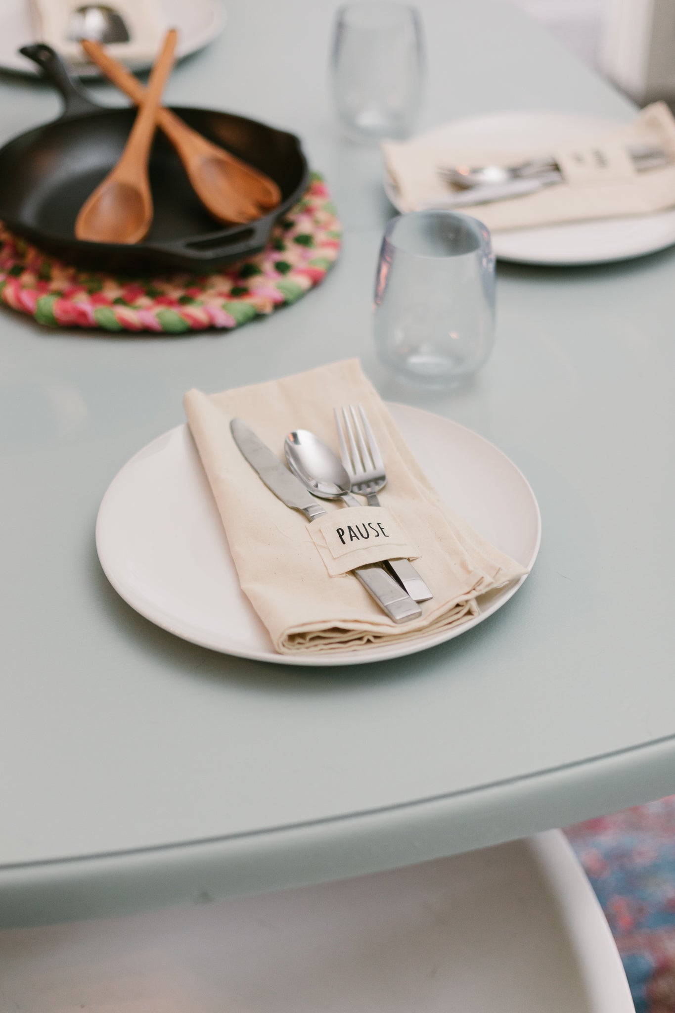 Pocket napkin set of four, skillfully crafted from up-cycled fabric, folded with a eucalyptus sprig and wooden ring, labeled "SAVOR.