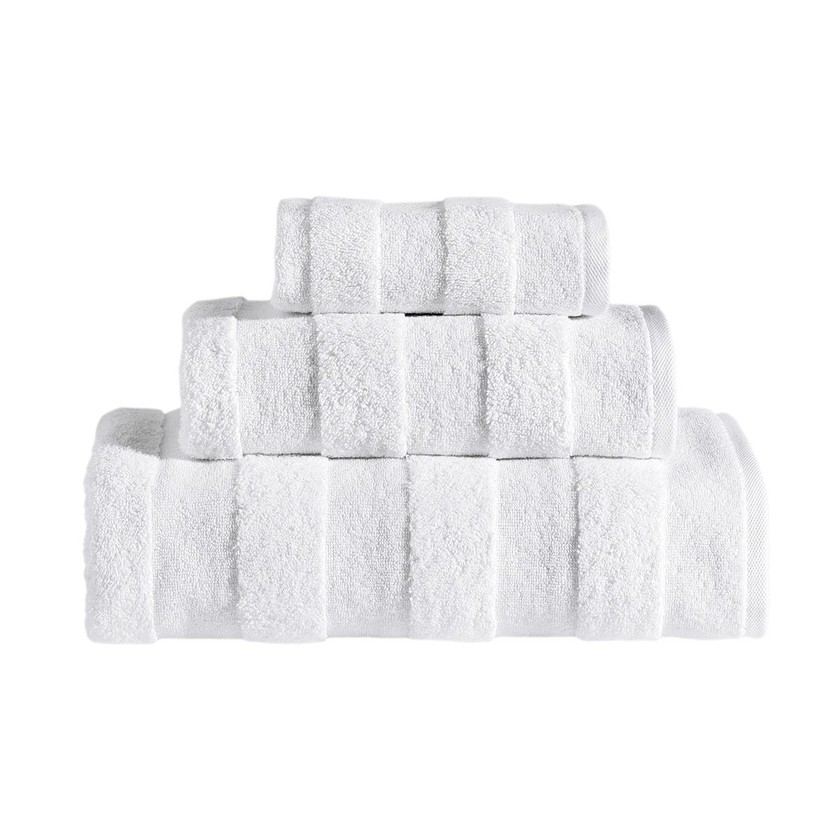 The Apogee Collection 3 PK Towels Set, featuring luxurious towels in white, blue, pink, and gray, is expertly arranged on a shelf. Nearby, small bottles and bars of soap complement the display with their decorative touch. Crafted from ultra-soft cotton, these towels enhance any bathroom experience with their plush texture.