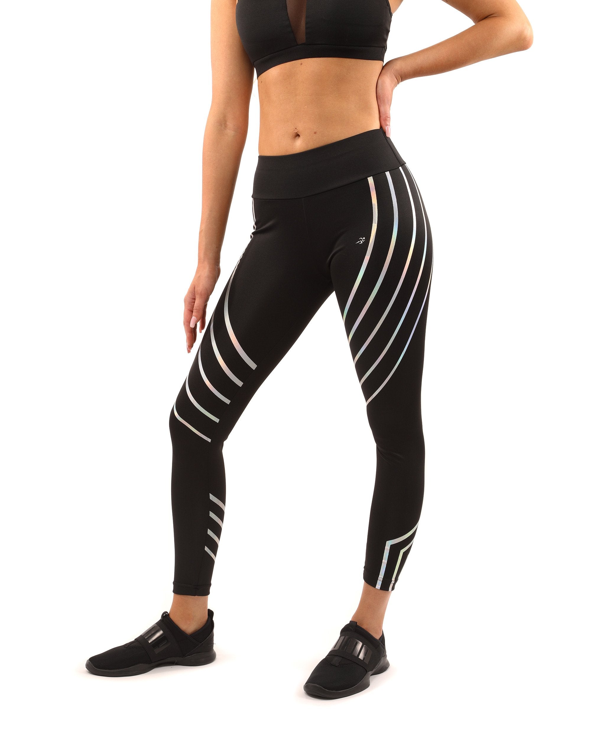 A person wearing the Laguna Leggings in black, featuring curved reflective stripes, along with a matching sports bra, stands confidently against a plain background, highlighting the sculpted compression fit.