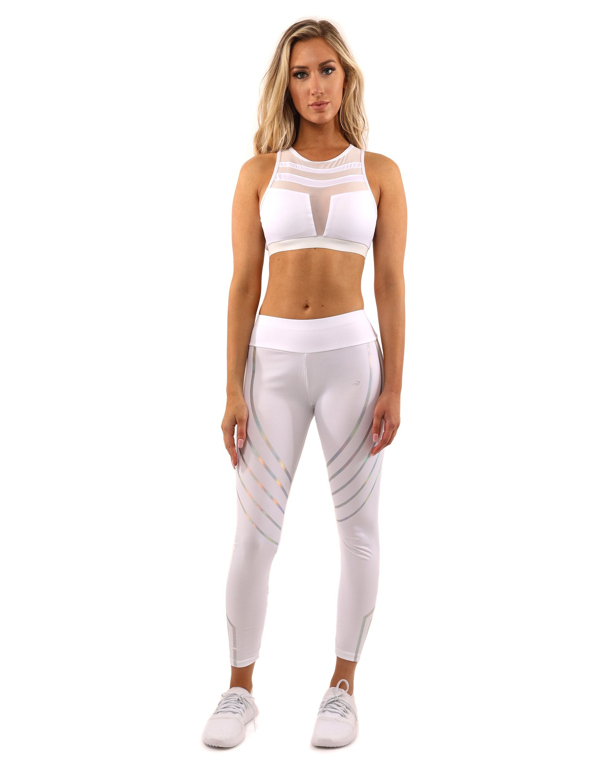 A person wearing the white Laguna Sports Bra and athletic pants with a racerback design, set against a white background.