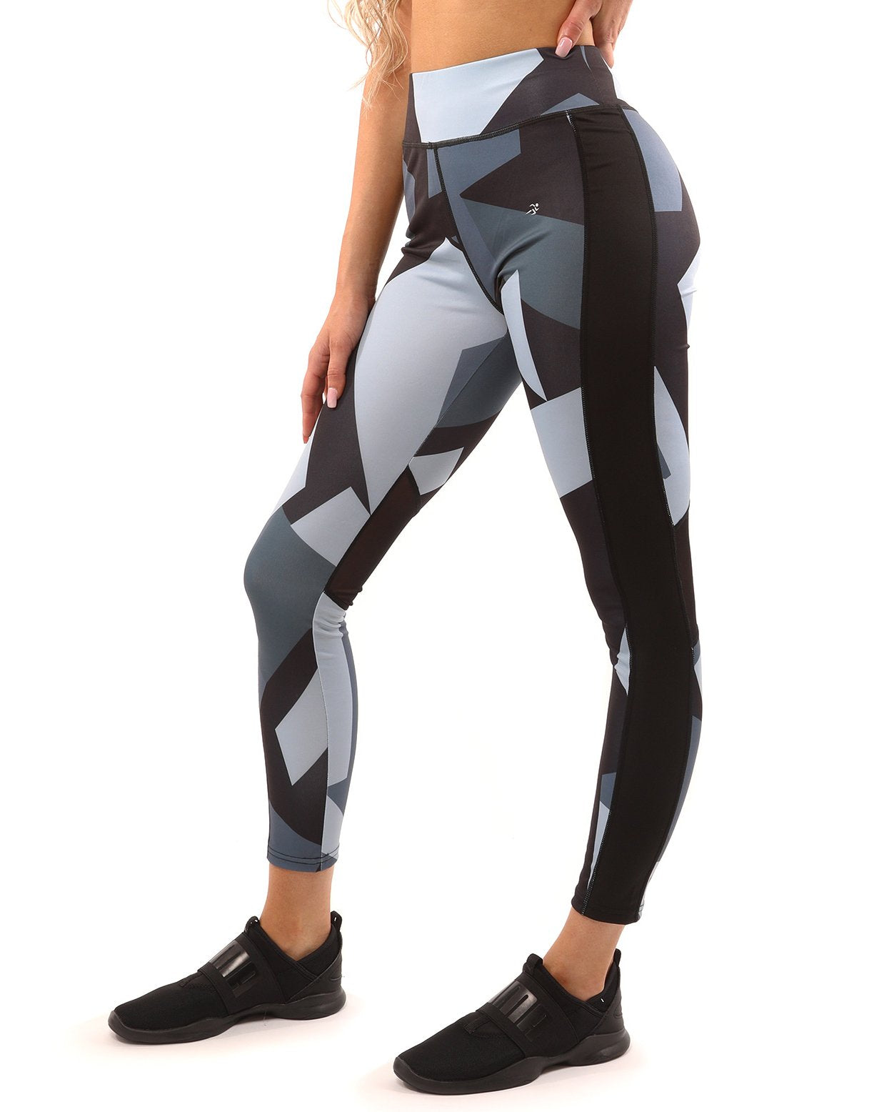 A person stands against a white background, highlighting the stylish Bondi Set in Black/Grey, featuring a geometric-patterned sports bra and compression fit leggings.