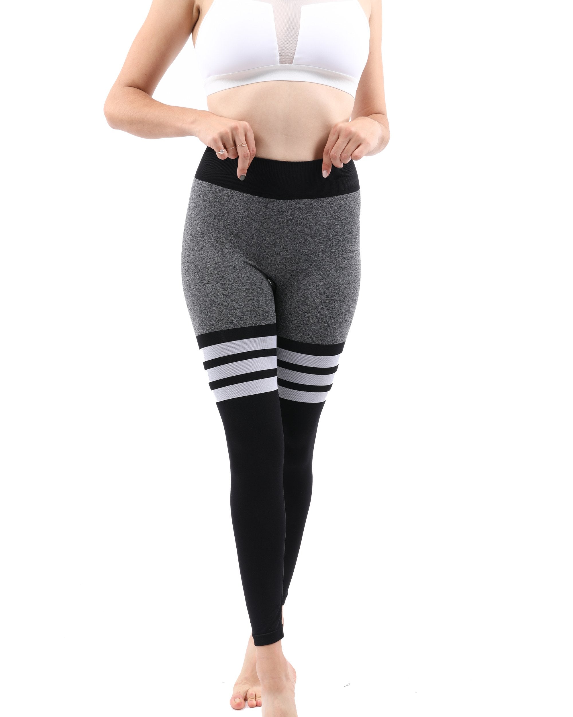 Person wearing Cassidy Legging - Black with a bent knee pose and black sneakers, side view.