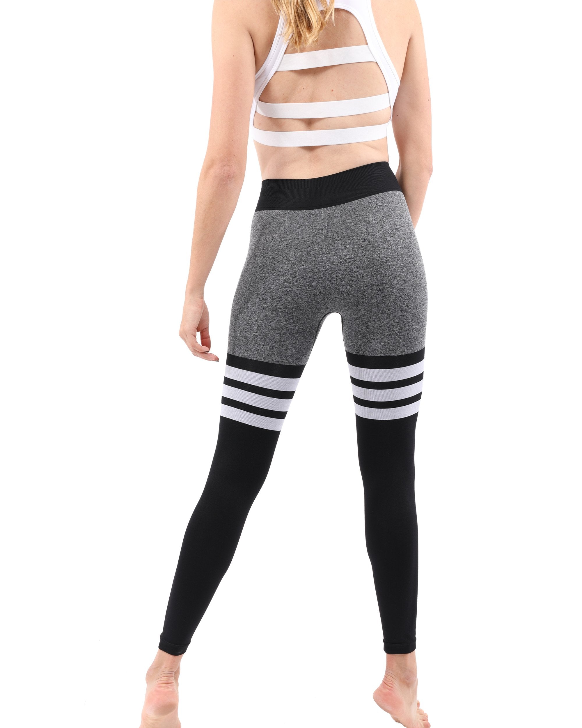 Person wearing Cassidy Legging - Black with a bent knee pose and black sneakers, side view.