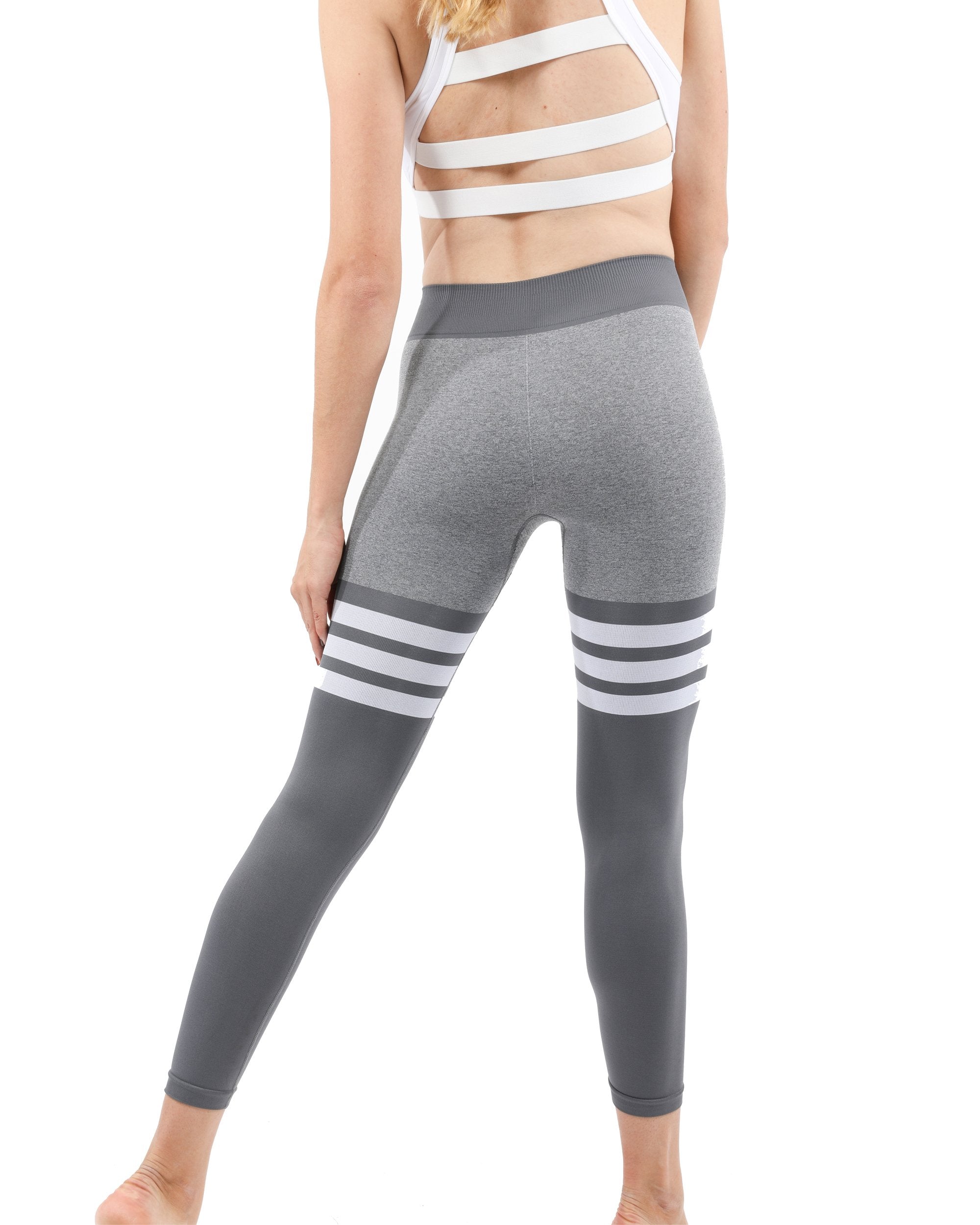 A person wearing the Cassidy Legging in gray with dark gray accents and white stripes stands against a white background.