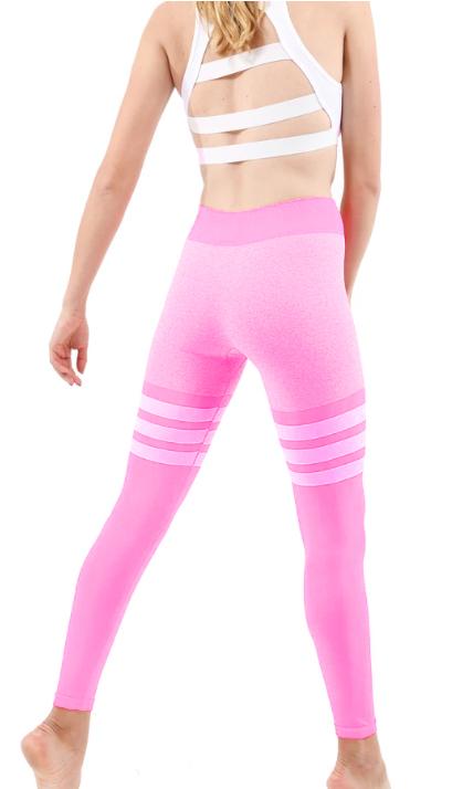 A person wearing Cassidy Legging - Pink stands on tiptoes against a plain background.