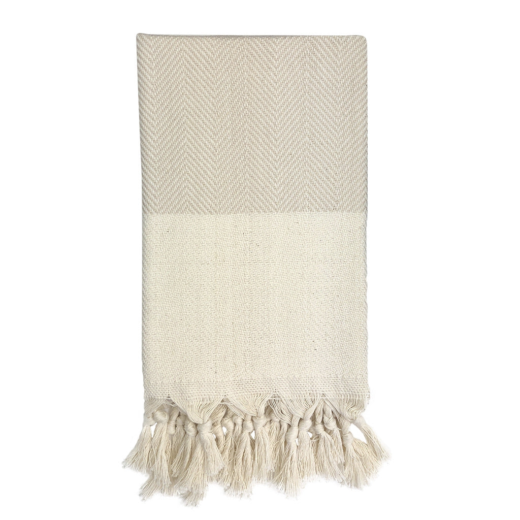 Product: The Herringbone Turkish Hand Towel is crafted from 100% Turkish cotton and displays a blue and white herringbone design, accented with a cream fringe border.